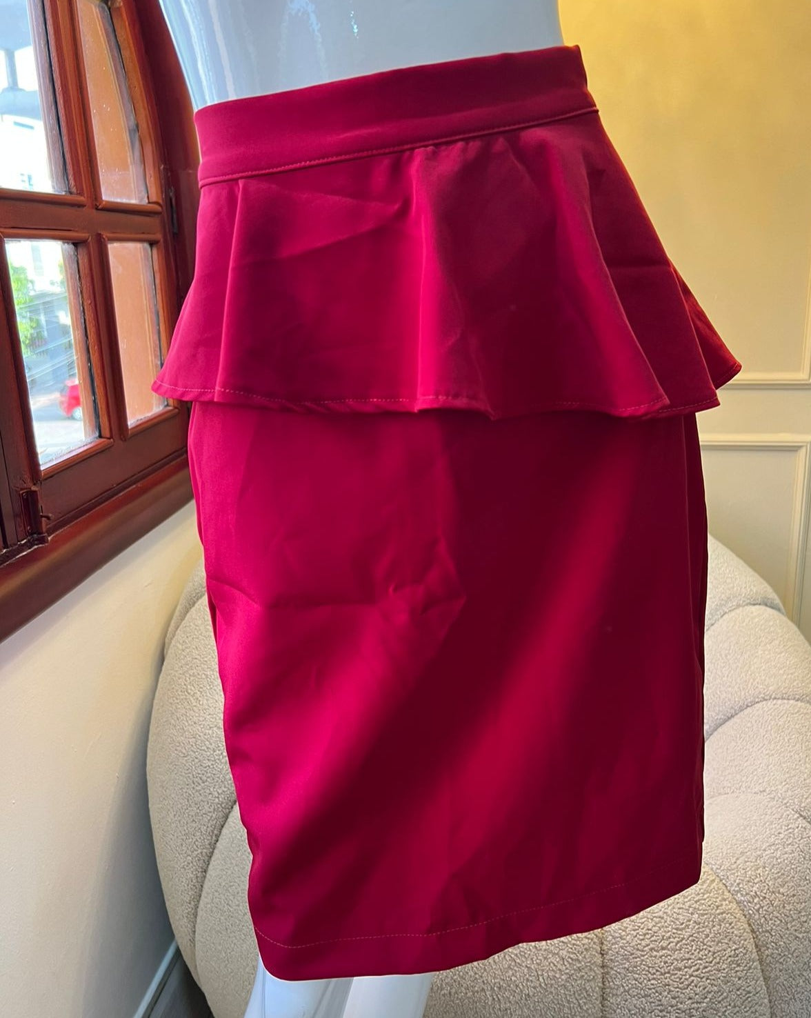 Falda roja con volante peplum, ideal para eventos y looks sofisticados. Diseño elegante y moderno de KIKE RODRIGUEZ.