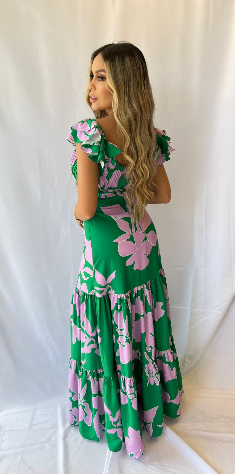 Mujer vistiendo un elegante vestido largo verde estampado floral de KIKE RODRIGUEZ, ideal para eventos especiales y ocasiones elegantes.