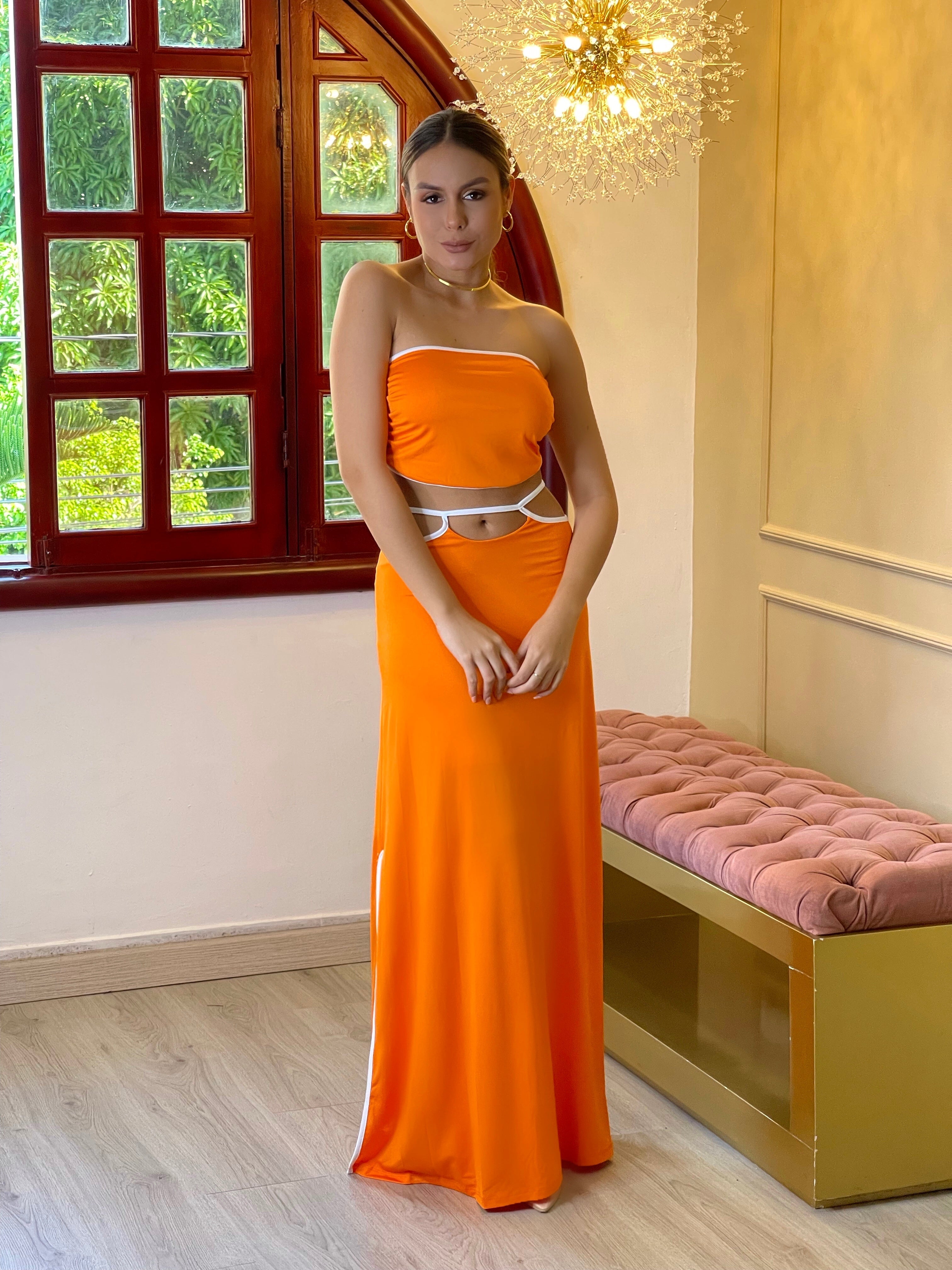 Mujer con elegante vestido naranja con detalles blancos en oferta de KIKE RODRIGUEZ, ideal para eventos y ocasiones especiales.