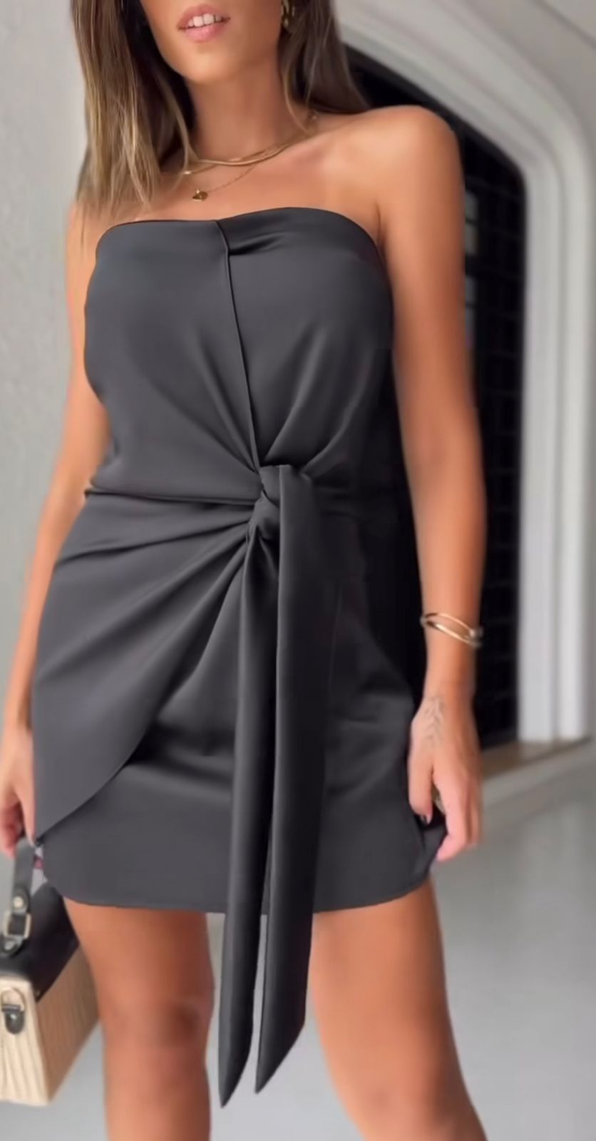 Mujer vistiendo el Vestido Negro Elegante de Kike Rodriguez con un detalle frontal único, perfecto para eventos formales y ocasiones especiales.